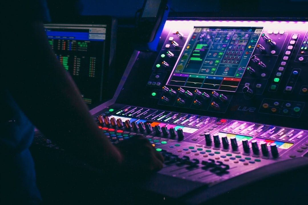 Ljudtekniker arbetar vid ett belyst mixerbord i en mörk studio